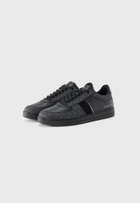 Black sneakers made of leather and fabric, featuring a geometric pattern, lace-up design, and a glossy accent on the side.