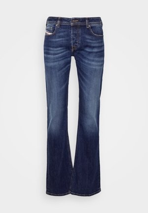 Denim flared jeans i mørkeblå med en falmet vask. Har lommer, bæltested og kontrasterende syninger. Standard fem-lomme design.