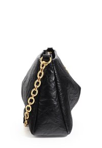 Bolso de mano de cuero negro con una superficie texturizada, que presenta una correa de cadena dorada y una forma triangular. No hay logotipos ni patrones visibles.
