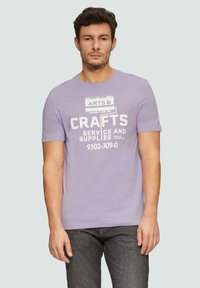 Lila t-shirt met korte mouwen, voorzien van witte bedrukte tekst over kunst en ambachten. Zachte stof met een casual pasvorm en een ronde hals.