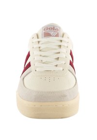Leather and suede sneaker in cream and maroon with textured upper, white laces, and logo detail on tongue. Perforated toe design.