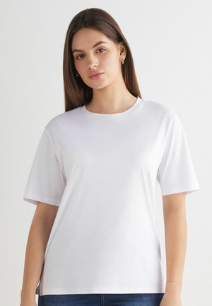 T-shirt bianco a maniche corte realizzato in cotone liscio con scollo rotondo; presenta una vestibilità comoda e un design delle spalle senza cuciture.