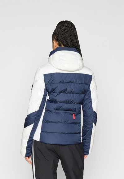 Πανωφόρι με επένδυση με ναυτικό και λευκό σχέδιο, διαθέτει κουκούλα, τσέπη με φερμουάρ και αντίθετους πάντες. Λείο υλικό και καπιτονέ τμήματα.