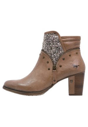 Bottine marron en cuir texturé avec un panneau en tissu pailleté, décorée de clous et équipée d'un talon épais pour plus de stabilité.
