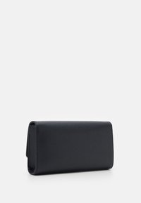 Pochette rectangulaire texturée noire reposant sur une surface blanche, vue d'un léger angle latéral.