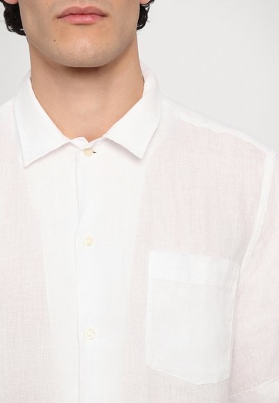 Camisa de lino blanca de manga corta con cuello abotonado, bolsillo frontal y botones color crema, que presenta una tela texturizada.