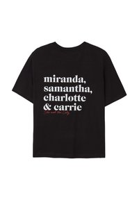 T-shirt nera con testo bianco che elenca "miranda, samantha, charlotte & carrie" e "Sex and the City" in corsivo rosso sotto.