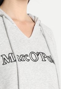 Grauer Hoodie mit einem V-Ausschnitt-Design, das ein schwarzes gesticktes Logo "Marc O'Polo" auf der Vorderseite und eine Kordelzugdetails an der Kapuze aufweist.