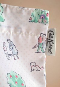Višenamjenska torba s pastelnim cvjetnim dizajnom koja sadrži ilustracije ljudi i životinja. Izrađena od tkanine s oznakom "Cath Kidston."