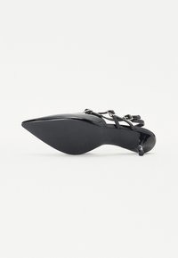 Crne patent kožne visoke potpetice s šiljastim nosom, uskim remenčićima oko gležnjeva i teksturiranom potplatom. Sadrži stiletto potpeticu i elegantan dizajn.