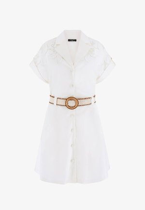 Biała sukienka z krótkim rękawem zapinana na guziki, z kwiatowym haftem na ramionach, podwiniętymi rękawami i plecionym paskiem z okrągłą klamrą w talii.