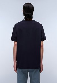 Tricou negru cu mânecă scurtă și guler rotund, realizat dintr-un material moale și neted. Purtați cu pantaloni gri, văzuți din spate.
