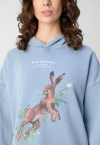 Scotch & Soda WASHED ARTWORK OVERSIZED HOODIE - Jersey con capucha - lake blue