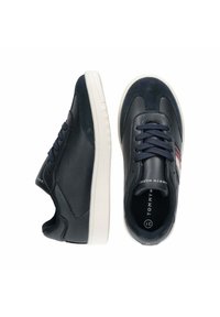 Sneakers in pelle blu navy con texture liscia, suola in gomma bianca, punta rotonda e lacci scuri. Presentano accenti a righe in rosso e bianco.