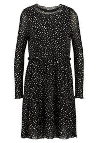 Musta mekko pitkillä hihoilla, jossa on valkoisia pilkkuja, kerroksellinen muotoilu ja röyhelökoristeet vyötäröllä ja helmassa. Läpinäkyvä kangas.