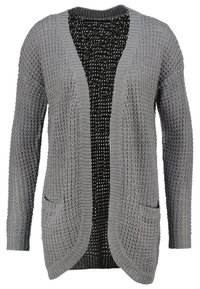 Grå stickad cardigan med ett texturerat mönster, öppen front och två sidofickor. Har ett svart inre lager med en subtil prickig design.