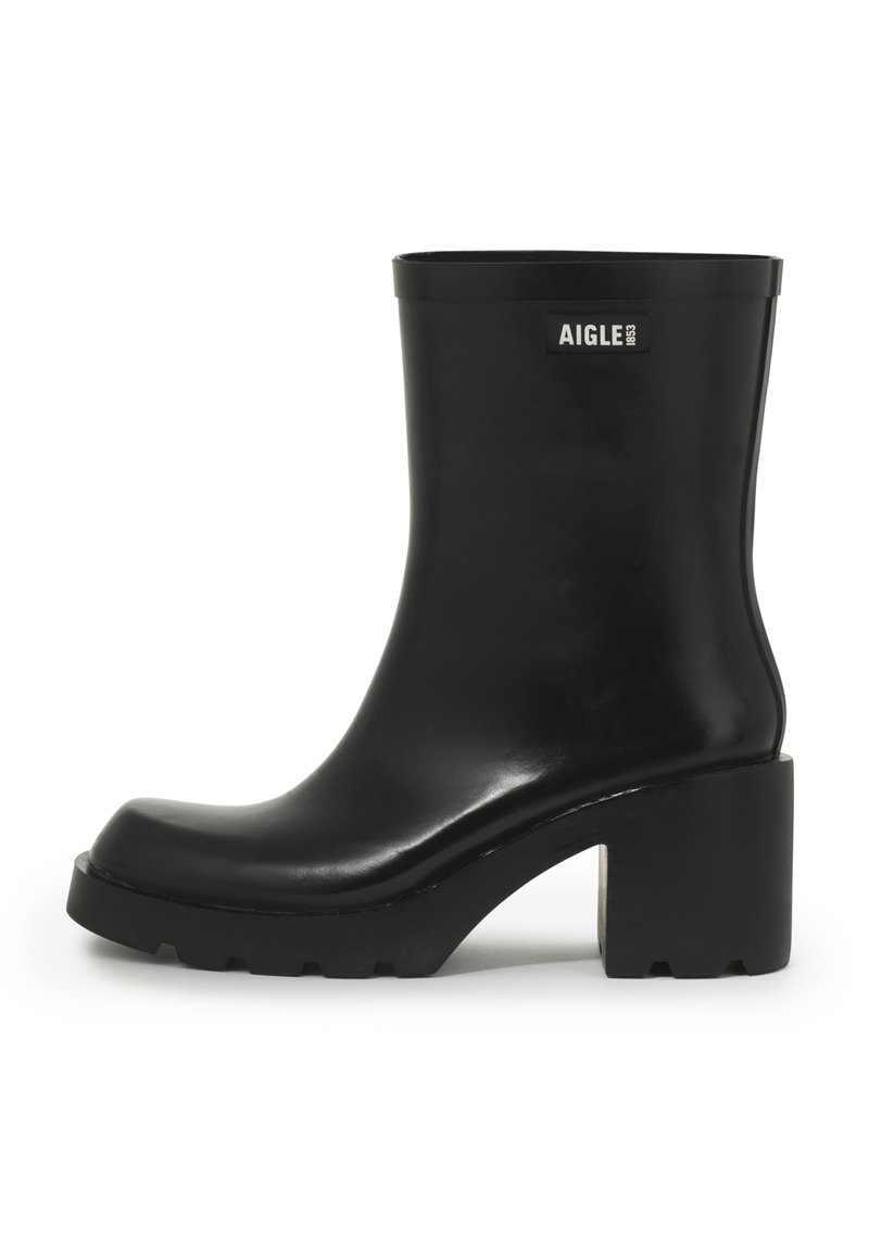 Black rubber ankle boot with a chunky heel, rounded toe, smooth finish, and a logo accent on the outer side. Textured sole for traction.