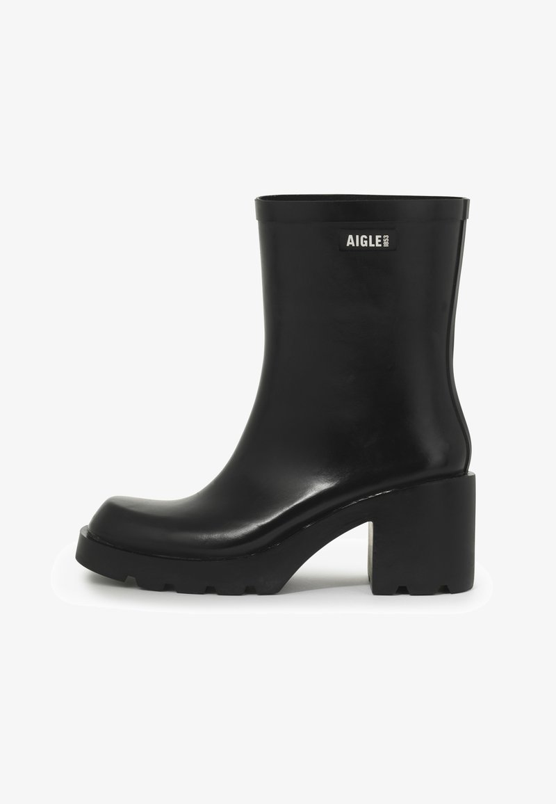 Czarne gumowe botki za kostkę z masywnym obcasem, okrągłym noskiem, gładkim wykończeniem oraz logo po zewnętrznej stronie. Teksturowana podeszwa dla lepszej przyczepności.