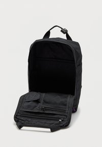 Zaino nero con maniglia superiore e scomparto frontale completamente aperto che mostra diversi scomparti con zip e in rete all'interno.