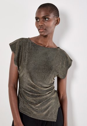Metallic gold Oberteil mit kurzen schwingenden Ärmeln, einem weiten Ausschnitt und geraffter Textur an der Seite. Getragen über schwarzen Hosen.