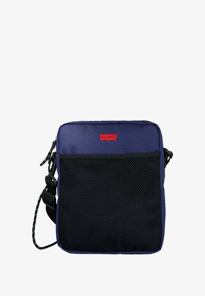 Bolso cuadrado azul marino con bolsillo frontal de malla, logo rojo de Levi's, correa ajustable y textura suave. Cierre con cremallera en la parte superior.