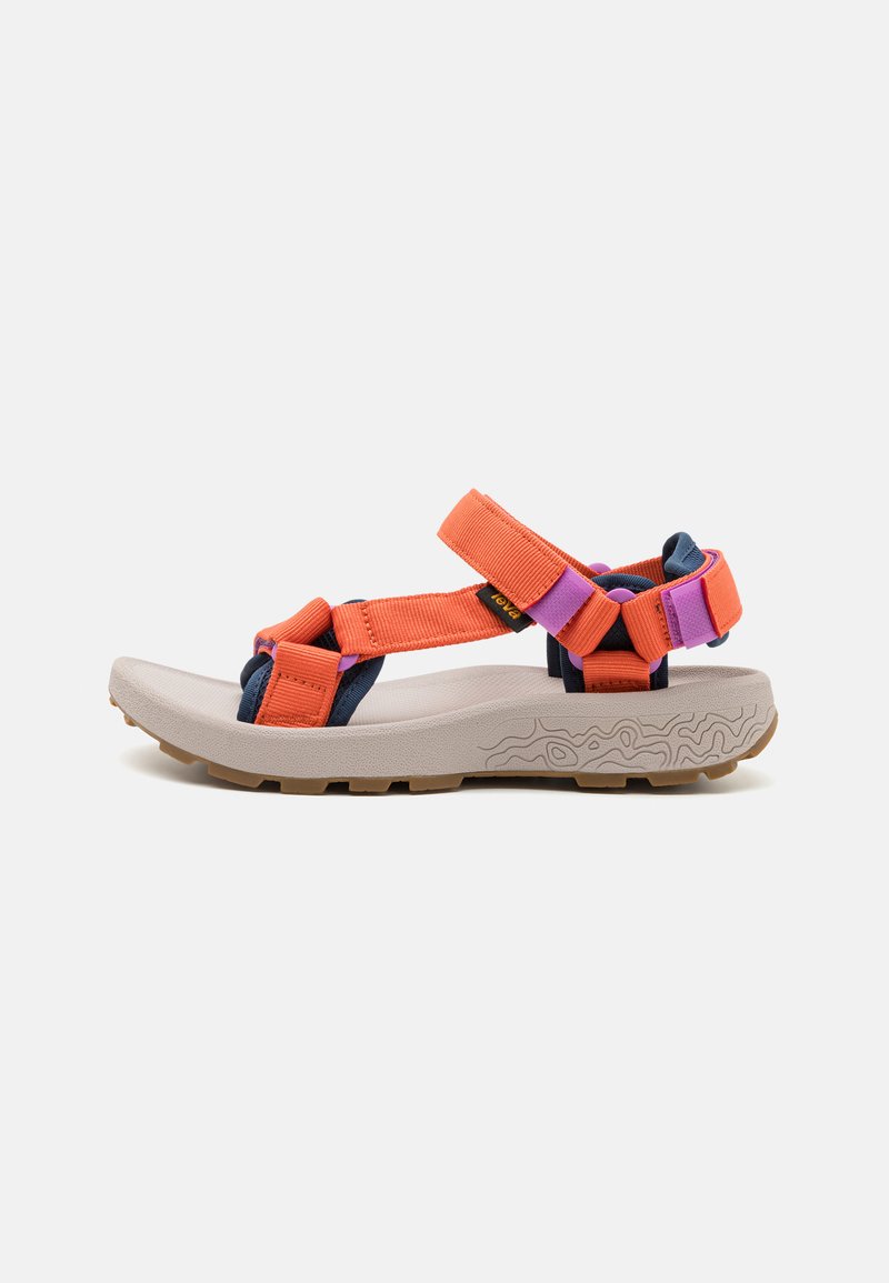 Sport sandaler med oransje og lilla stropper, marineblå detaljer og en teksturert beige såle. Har justerbare stropper og en polstret fotseng.