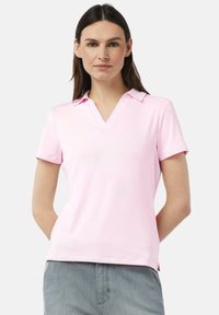 Helles rosafarbene Poloshirt mit V-Ausschnitt, kurzen Ärmeln und einer weichen Textur. Keine Muster oder Akzente. Einfaches, klassisches Design.