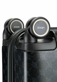 Valigia rigida nera con superficie goffrata e motivo floreale sottile, dotata di doppie ruote e chiusura con cerniera liscia.