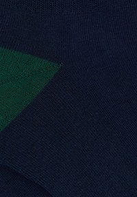 Calze blu scuro con un accento triangolare verde. Il tessuto presenta una consistenza morbida e una fine costina, garantendo comfort e durata.