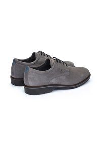 Chaussures en daim grises avec une texture lisse, un design à lacets, une pointe arrondie et de subtils accents de talons bleus. La semelle en caoutchouc offre une bonne traction.