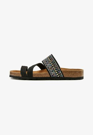 Black slide sandals feature a textured black strap with rhinestones in various colors, cork footbed, and a black rubber sole.