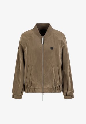 Giubbotto bomber marrone con colletto e polsini a coste, chiusura con zip, due tasche laterali e una piccola patch del logo sul petto. Tessuto liscio.