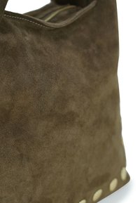 Braune Wildledertasche mit strukturierter Oberfläche, ausgestattet mit einer oberen Öffnung und dekorativen hellfarbenen Nieten entlang des unteren Randes.