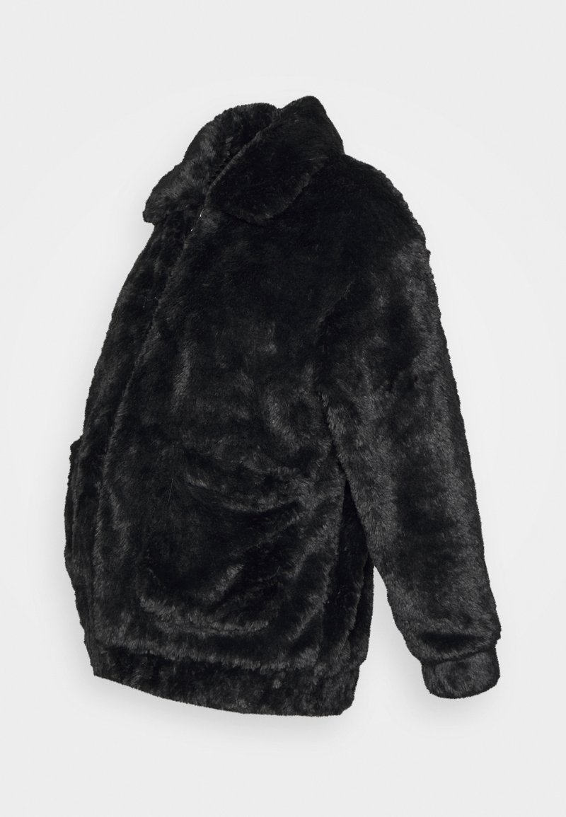 Casaco de pelo sintético preto com colarinho, bolsos laterais e uma silhueta ligeiramente oversized, apresentando uma aparência suave e texturizada.