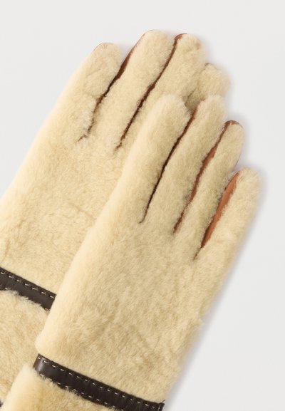 Γάντια από δέρμα αρνιού σε κρεμ χρώμα, με επένδυση στο εσωτερικό, καφέ δερμάτινες λεπτομέρειες και ραφές κατά μήκος του καρπού.