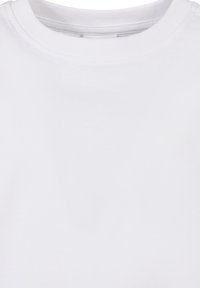 Paprasta balta marškinėliai su apvalia iškirpte ir dvigubu siuvimu aplink apykaklę, pavaizduoti ant lygios paviršiaus.