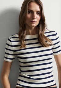 Maglietta a maniche corte a righe con righe orizzontali blu navy e crema. Il tessuto sembra liscio con un design aderente e un collo rotondo.