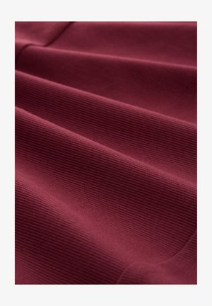Burgundy fabric with a ribbed texture, featuring waves and folds that emphasize softness and flexibility. Smooth and uniform surface.