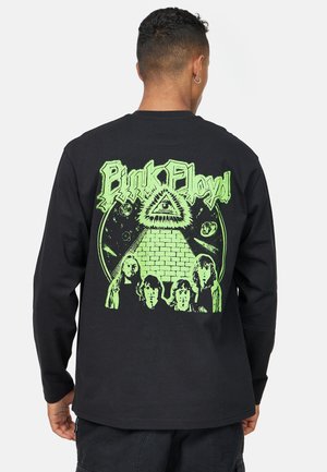 Svart långärmad t-shirt med en grön grafisk tryck av en pyramid och figurer, med "Pink Floyd"-text i fet stil.