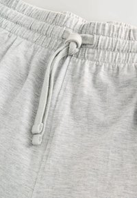 Šedé šortky s elastickým pásom a sťahovacou šnúrkou. Texturovaná bavlnená látka, jednoduchý dizajn a mäkký povrch pre pohodlie.