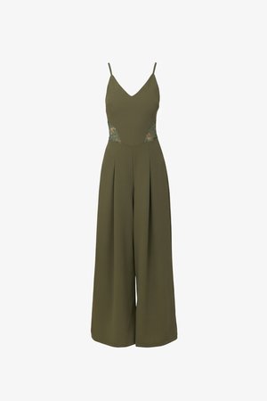 Ελιάς πράσινη ολόσωμη φόρμα χωρίς μανίκια με φαρδιές παντελόνες, λαιμόκοψη σε σχήμα V, λεπτές τιράντες και λεπτομέρειες δαντέλας με κοψίματα στη μέση.