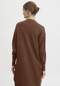 Bruine lange mouwen trui van zacht gebreid materiaal, met een losse pasvorm, geribbelde manchetten en een V-halsontwerp. Eenvoudige, minimalistische stijl.