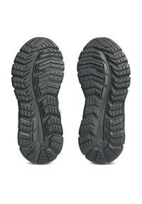 Suole di scarpe nere in gomma con scanalature profonde, caratterizzate da un motivo a zigzag e scanalature per una migliore aderenza. Design simmetrico senza marchi visibili.