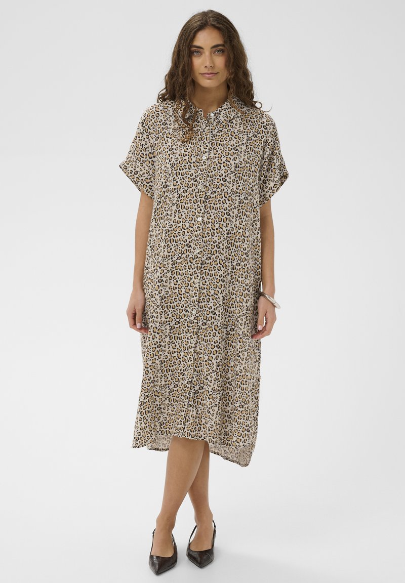 Robe imprimé léopard en tissu léger, avec manches courtes, fermeture boutonnée sur le devant et silhouette arrivant au genou avec un ourlet légèrement incurvé.