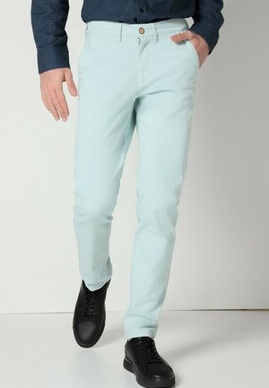 Pantalons vert menthe clair en tissu mélangé coton, avec une coupe ajustée, un devant plat et une fermeture à un bouton.