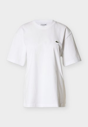 Wit katoenen T-shirt met een ronde hals en korte mouwen. Voorzien van een klein groen logo op de linkerborst. Regular fit en zachte structuur.