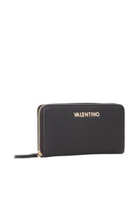 Portafoglio in pelle nera con superficie testurizzata, lettering del logo dorato e chiusura con zip. Forma rettangolare con profilo slim.