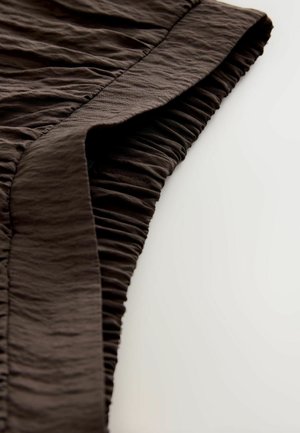 Dark brown fabric draping with a textured, gathered pattern along the edge. Soft, lightweight material with a subtle sheen.