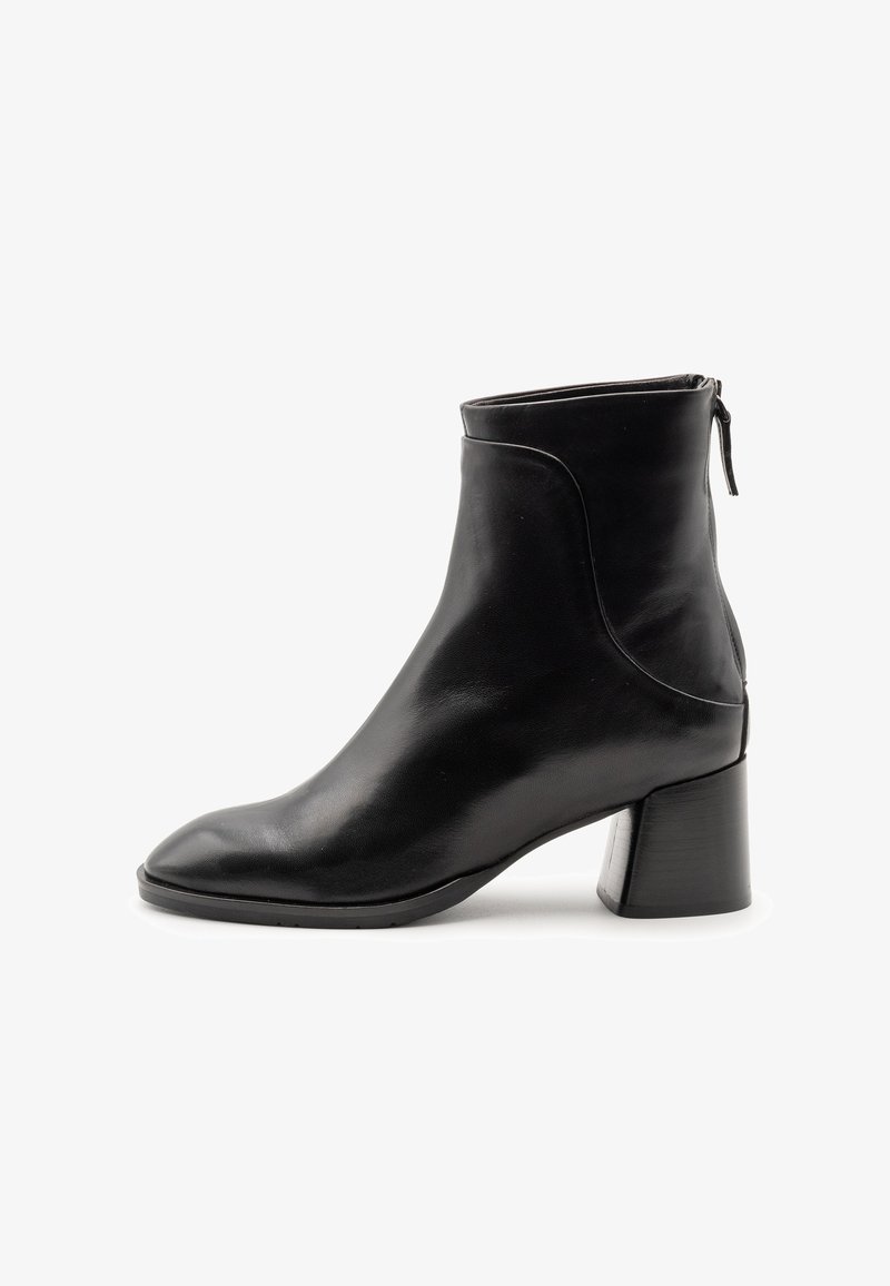 Stivaletto in pelle nera con punta quadrata e tacco chunky. Presenta una cerniera laterale e una texture liscia e lucida con cuciture minime.