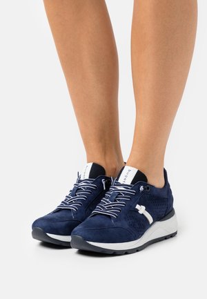 Marineblaue Wildledersneaker mit weißen Akzenten, perforierten Seiten, einer dicken weißen Sohle und kontrastierenden Schnürsenkeln für einen sicheren Halt.
